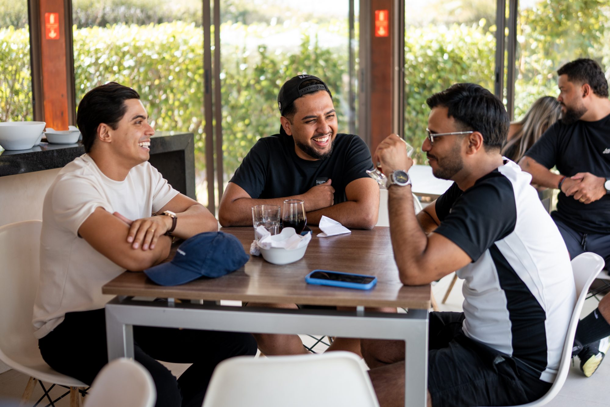 Três membros conversando à mesa